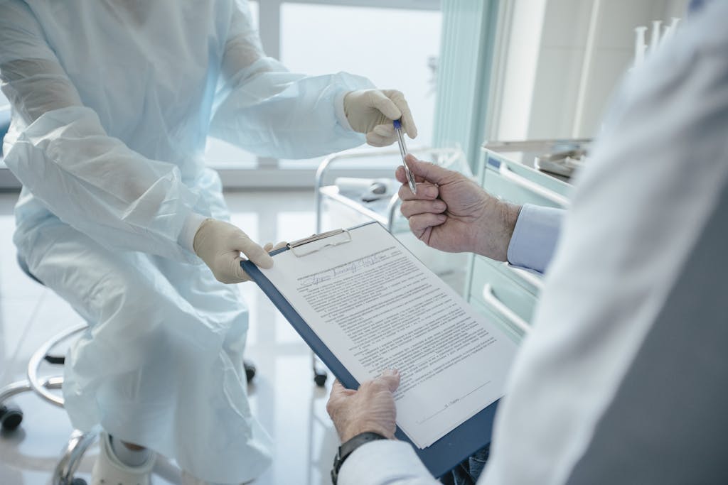 A doctor hands a clipboard to a patient for signature, highlighting medical professionalism.